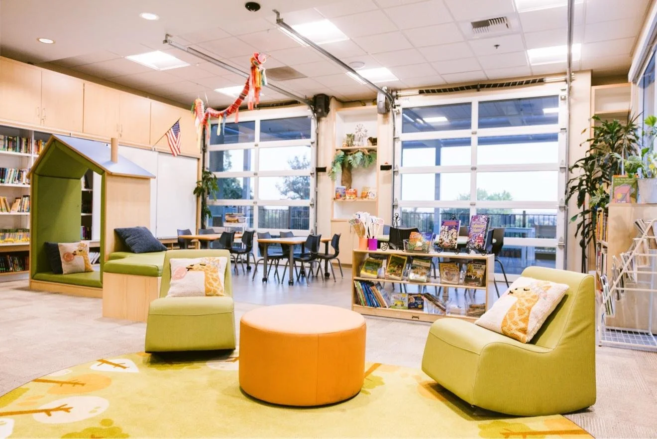 Library reading nook with green armchairs and an orange ottoman