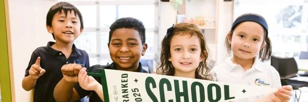 Four diverse CIS students in school uniforms smiling together in classroom, representing the welcoming school community