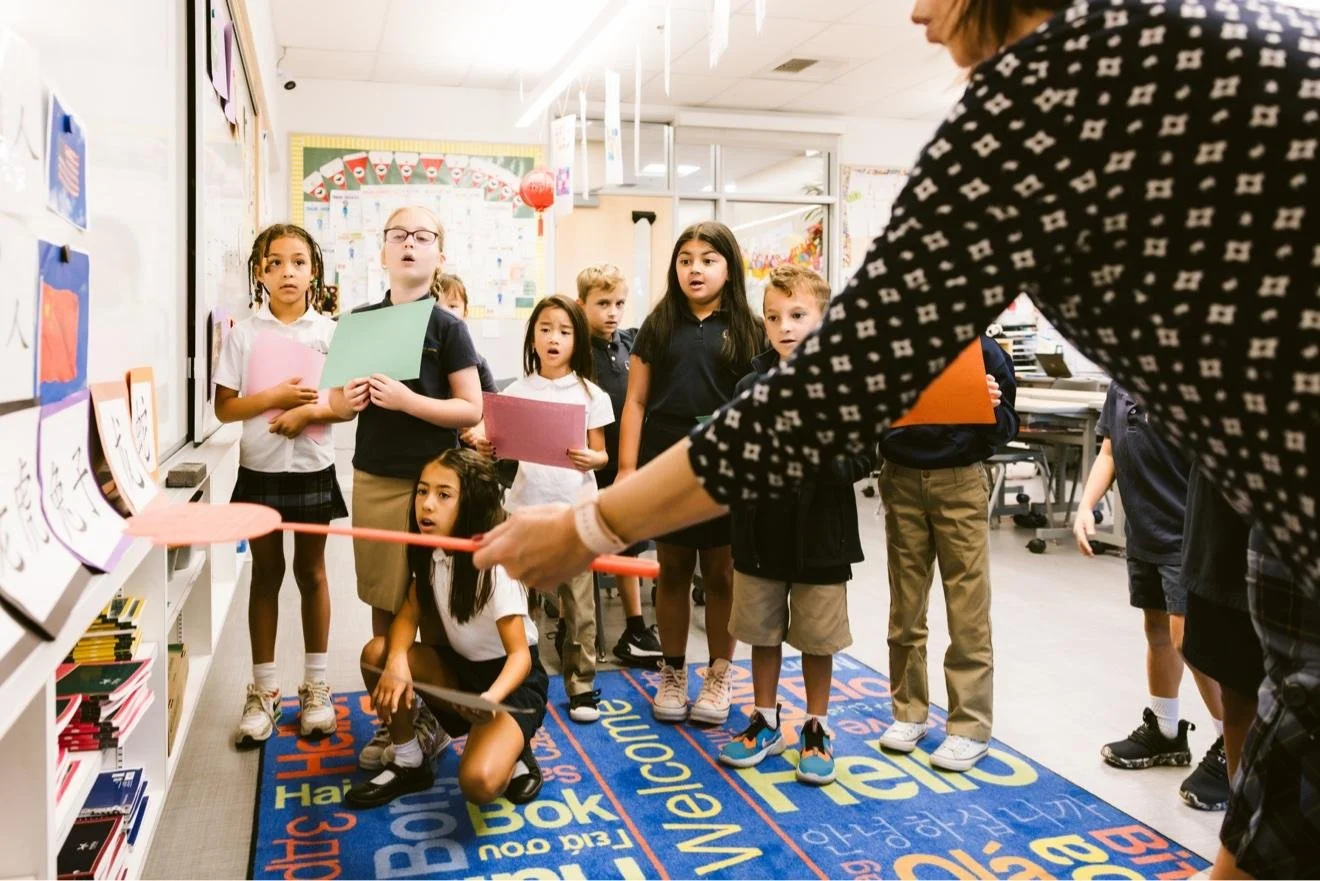 students playing a word game with their teacher on a classroom rug
