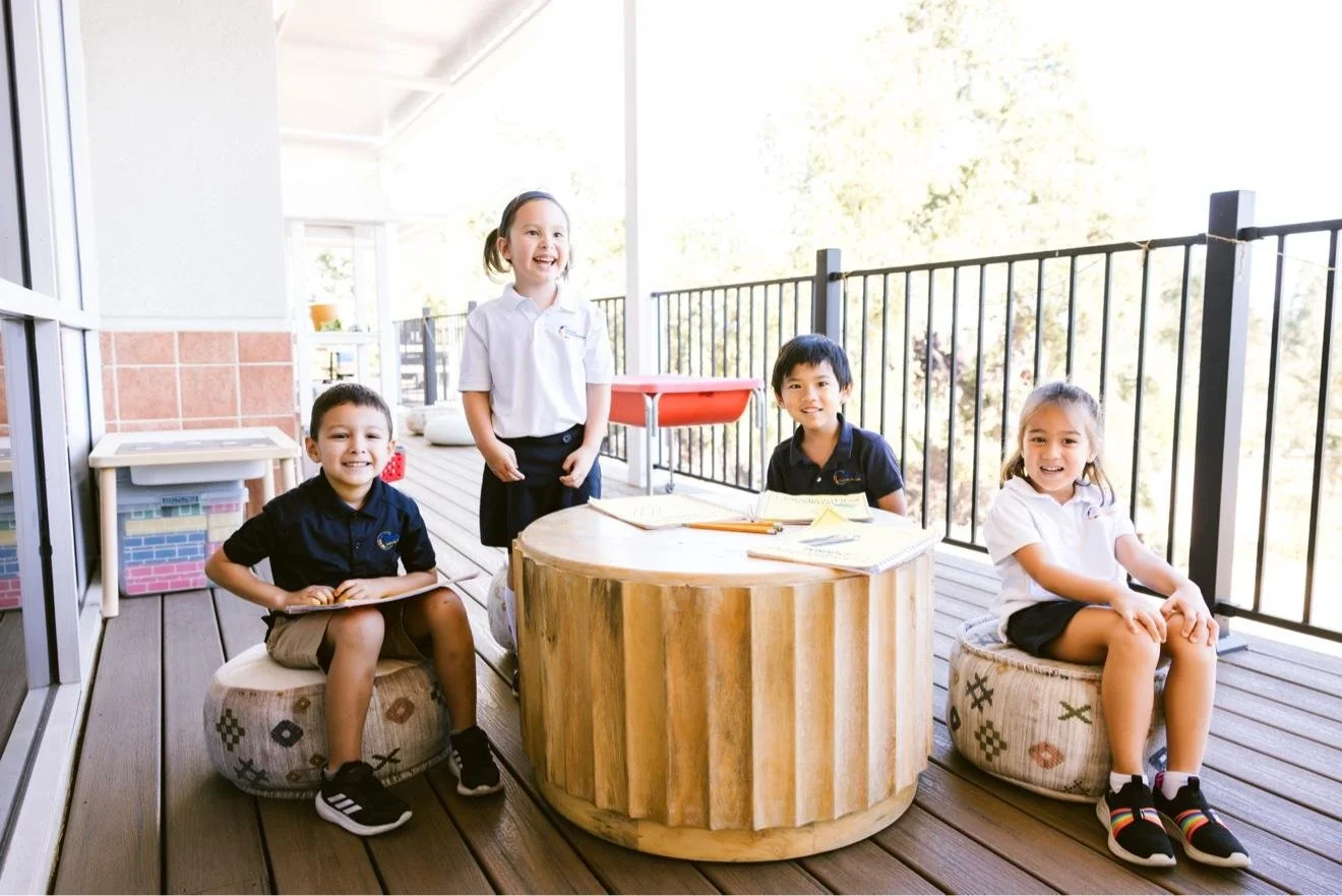 Students working at a round table on an outdoor deck
