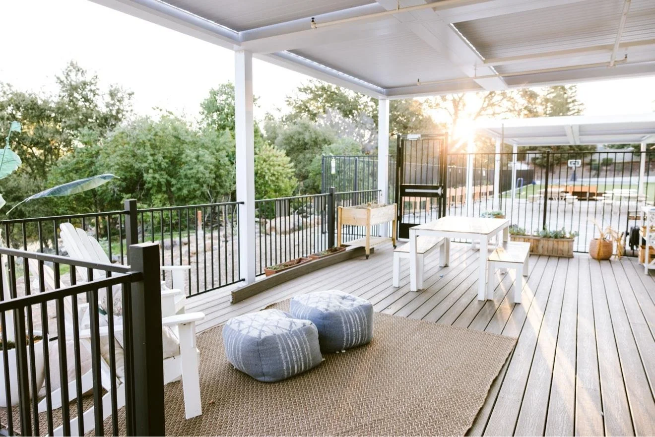 Covered outdoor deck with lounge seating and patio tables