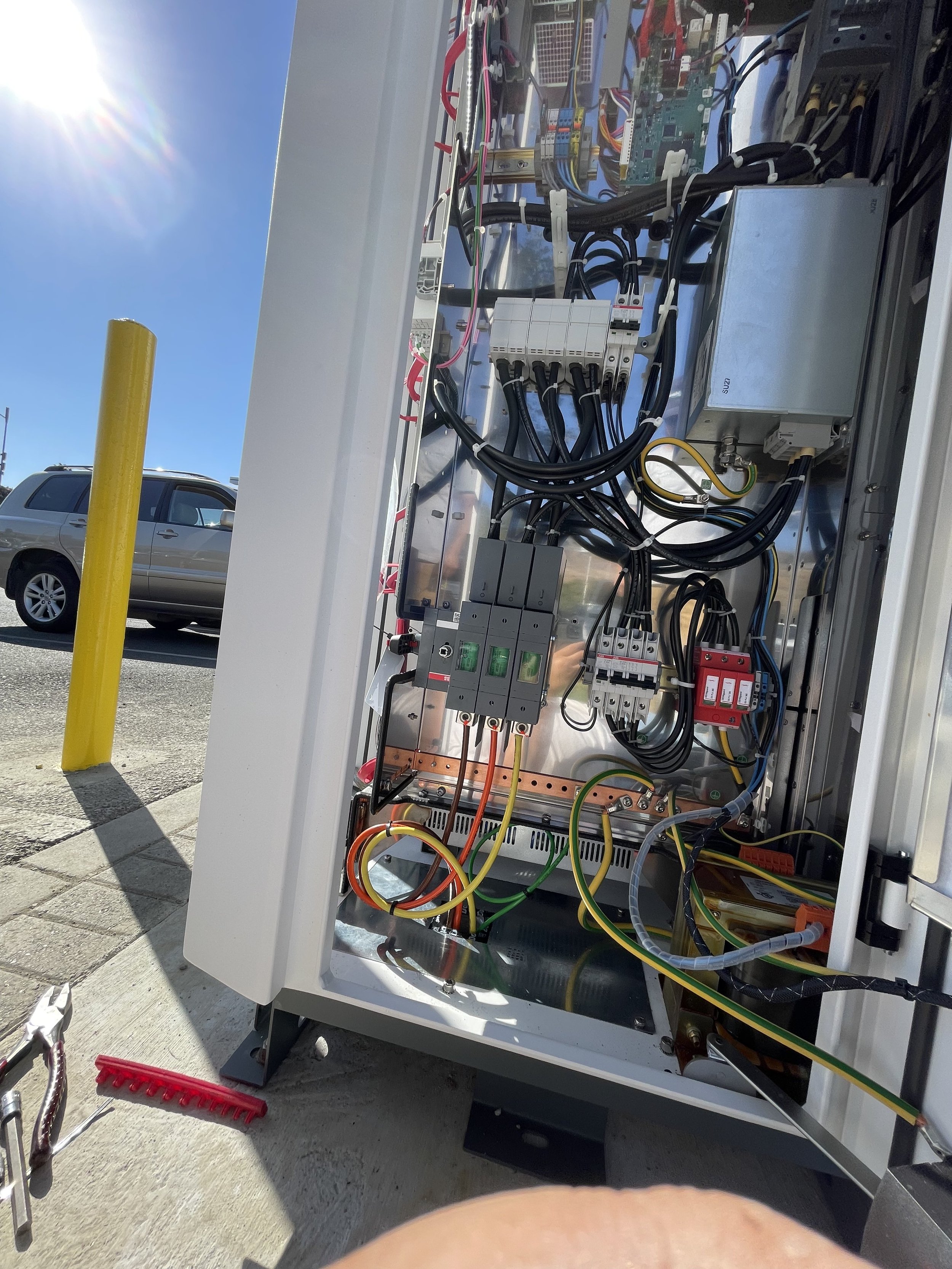 Open electrical control panel with wires and electronic components inside.