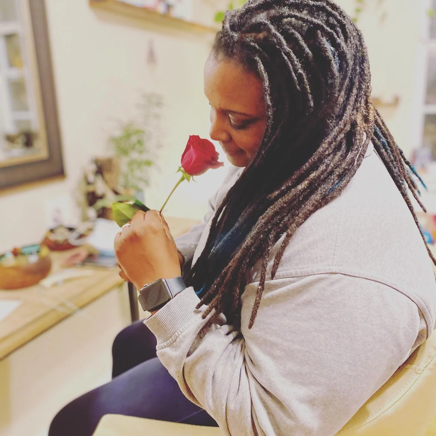 Three black bottles of WILD WOMAN LOCS shampoo with pump dispensers, placed on a textured stone surface outdoors with blurred greenery in the background.