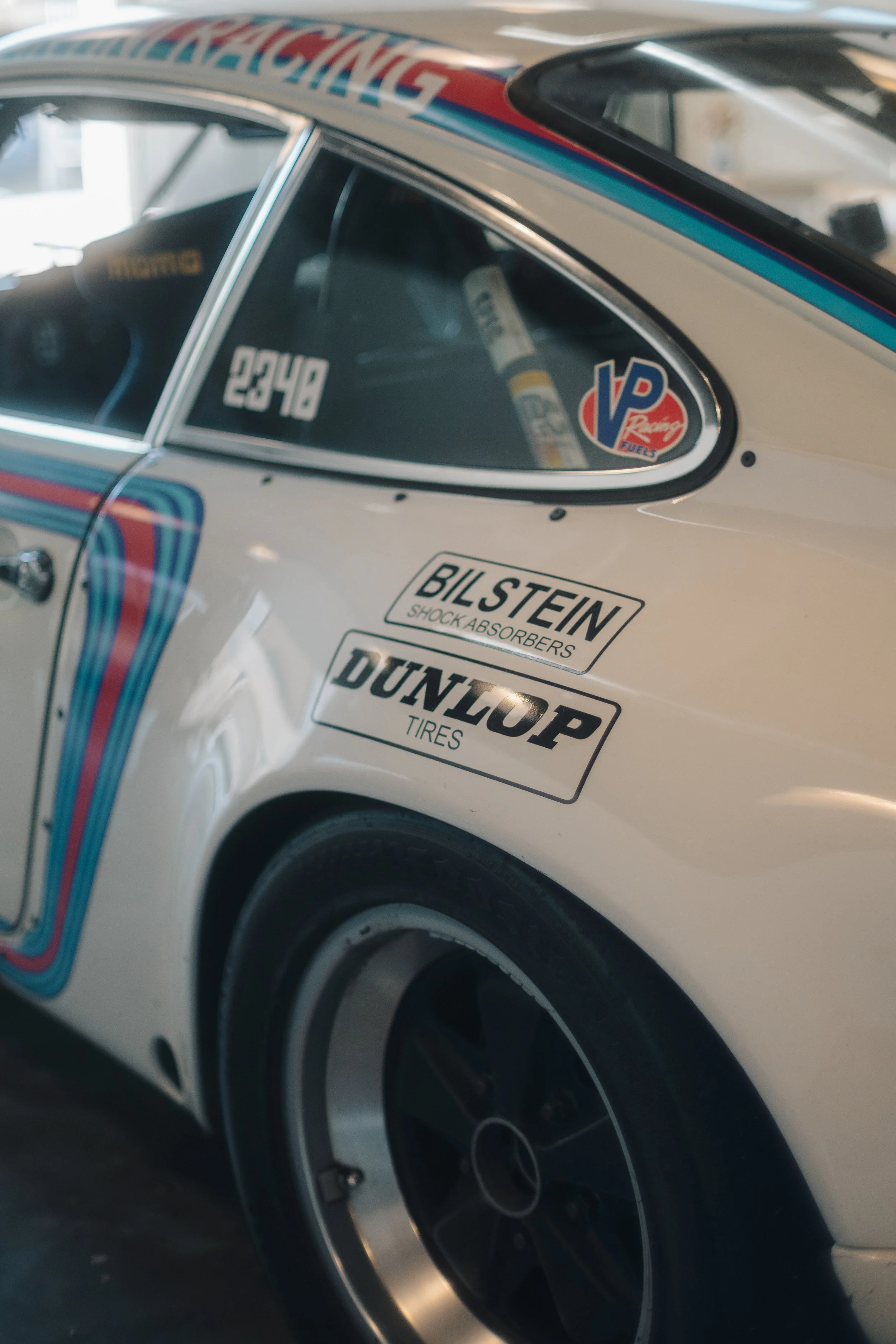 Close-up of a vintage race car with sponsor decals, a number '22', and racing tires.