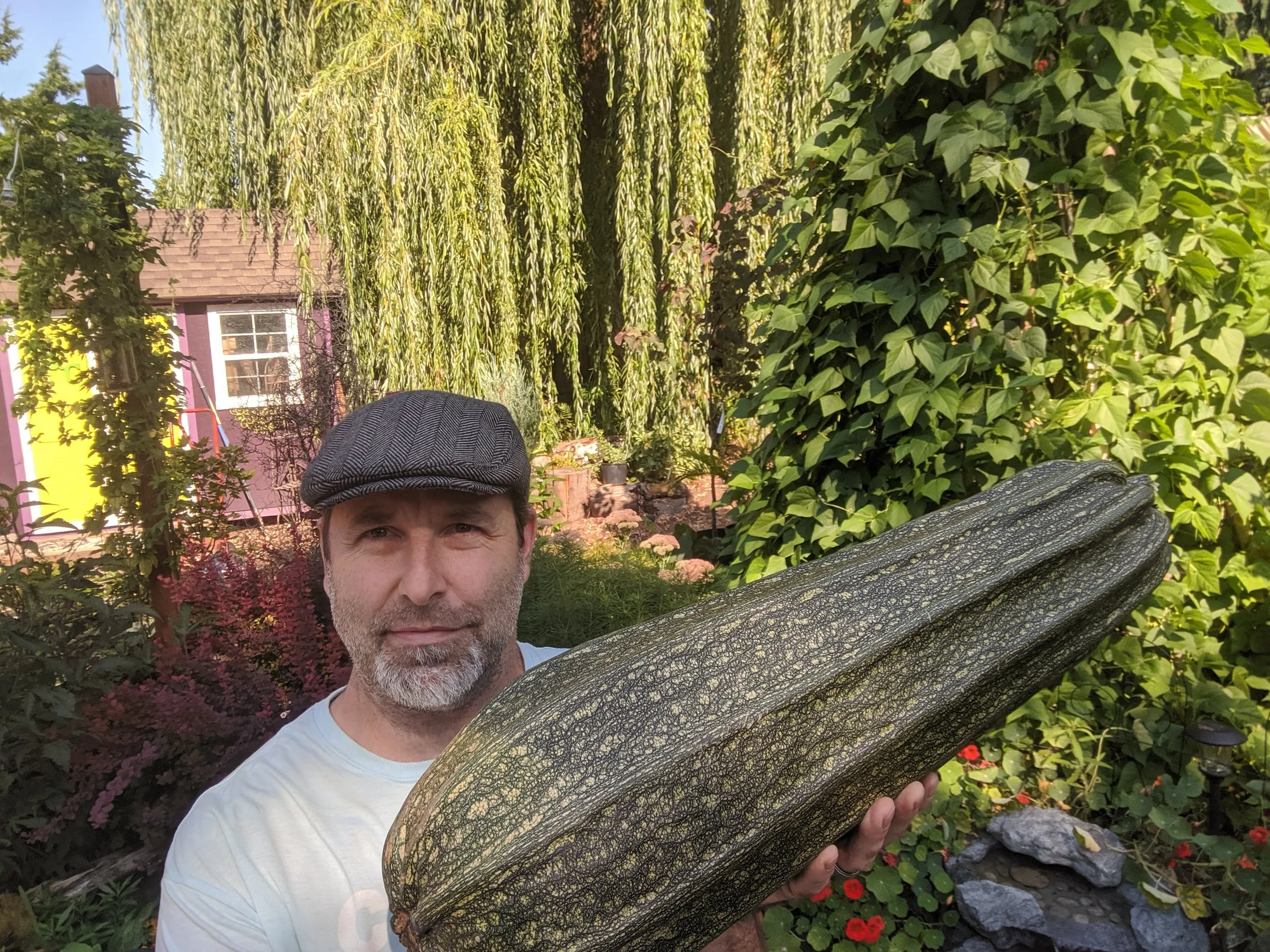 Christopher holding a huge overgrown zucchini from the garden