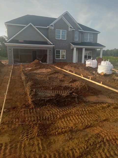 Grading a driveway for preparation of fresh asphalt