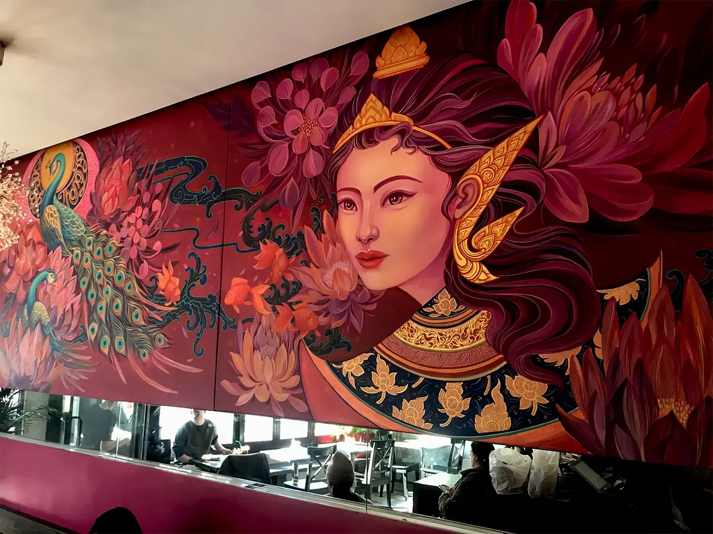 Vibrant mural depicting a fantasy woman with elaborate jewelry, surrounded by flowers, koi fish, and peacock feathers.