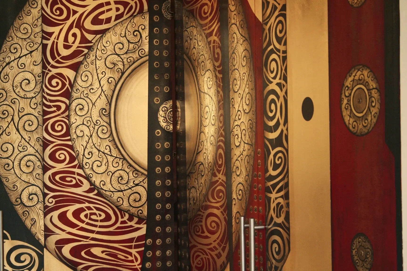 Ornate elevator interior with swirling black and red patterns and circular decorative elements.