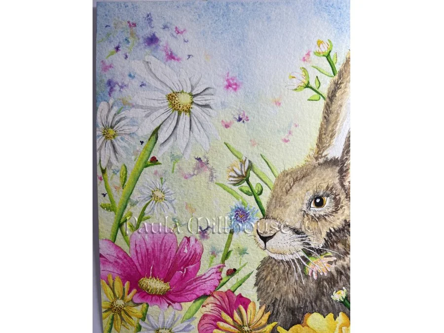 Brown hare sitting among colorful spring wildflowers including tulips and daisies, wildlife watercolor by Paula Millhouse.