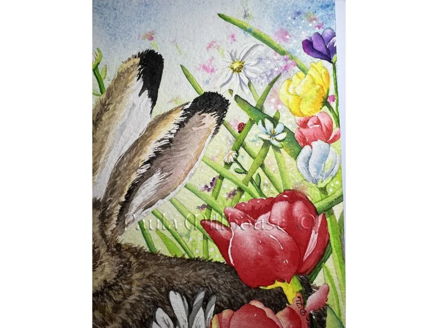 Brown hare sitting among colorful spring wildflowers including tulips and daisies, wildlife watercolor by Paula Millhouse.