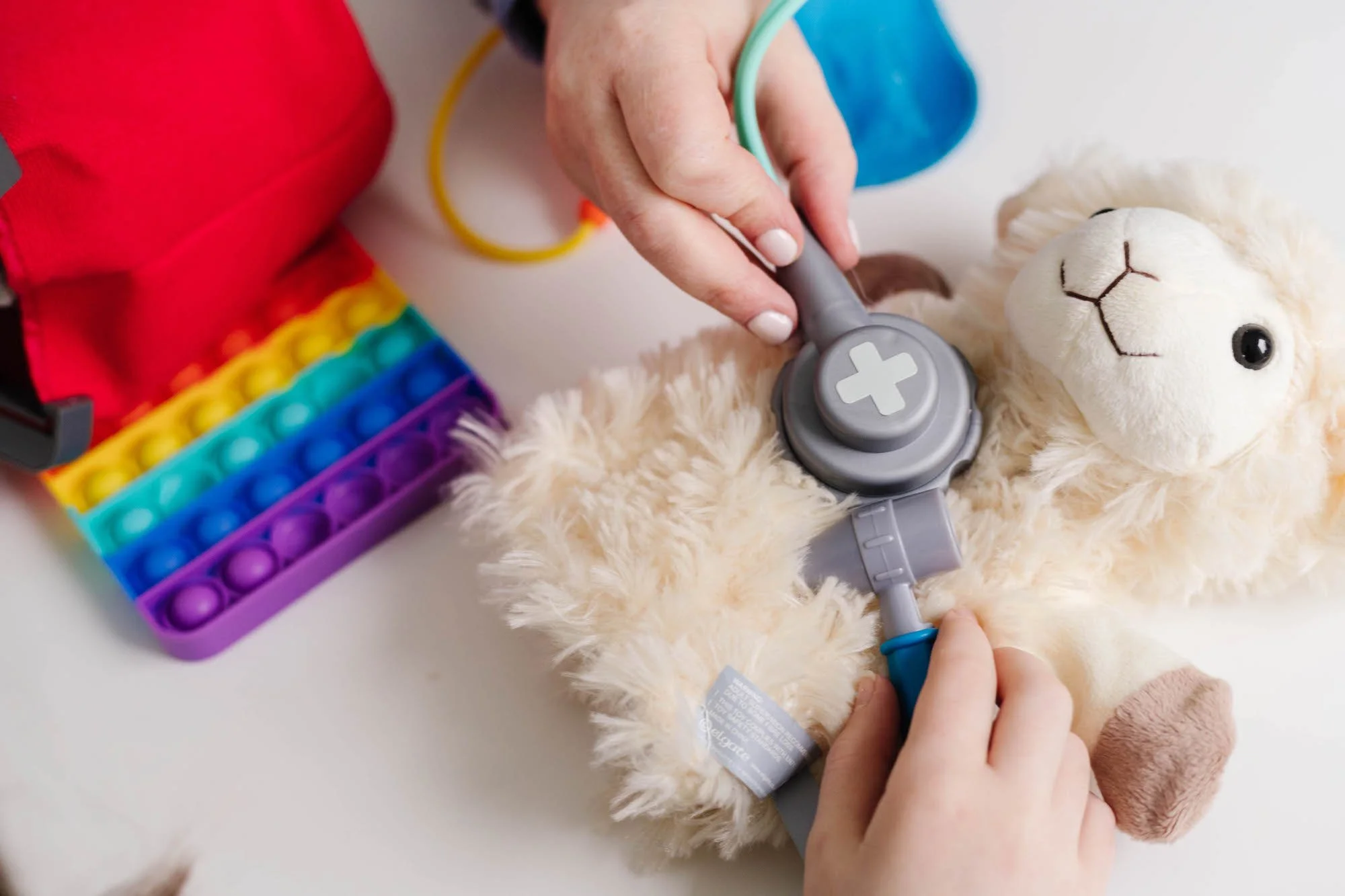 Clinical psychologist Dr Jill Pollard 'playing' doctor with a child, using a soft toy