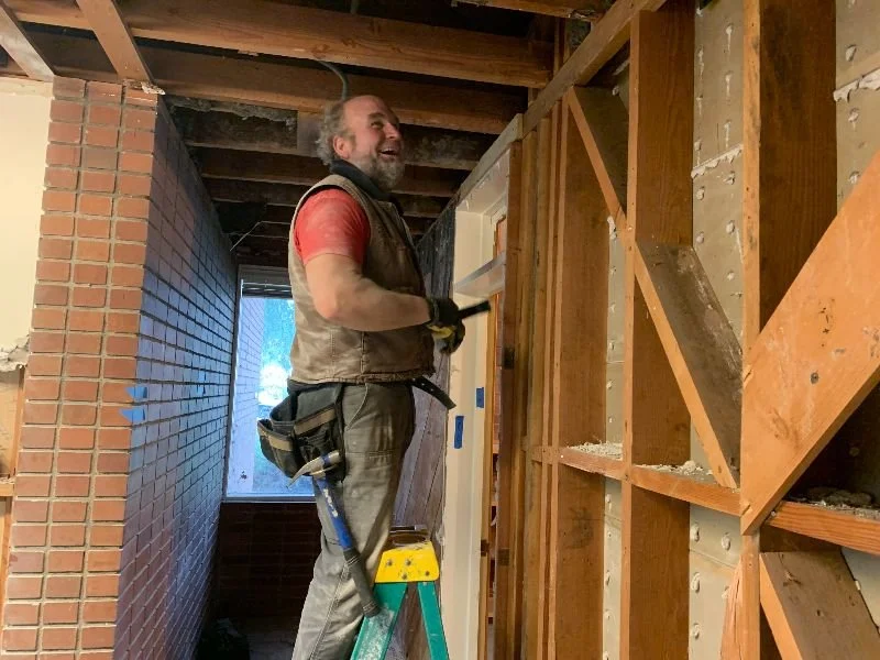 A man standing on a ladder, working on Clay Street demolition.