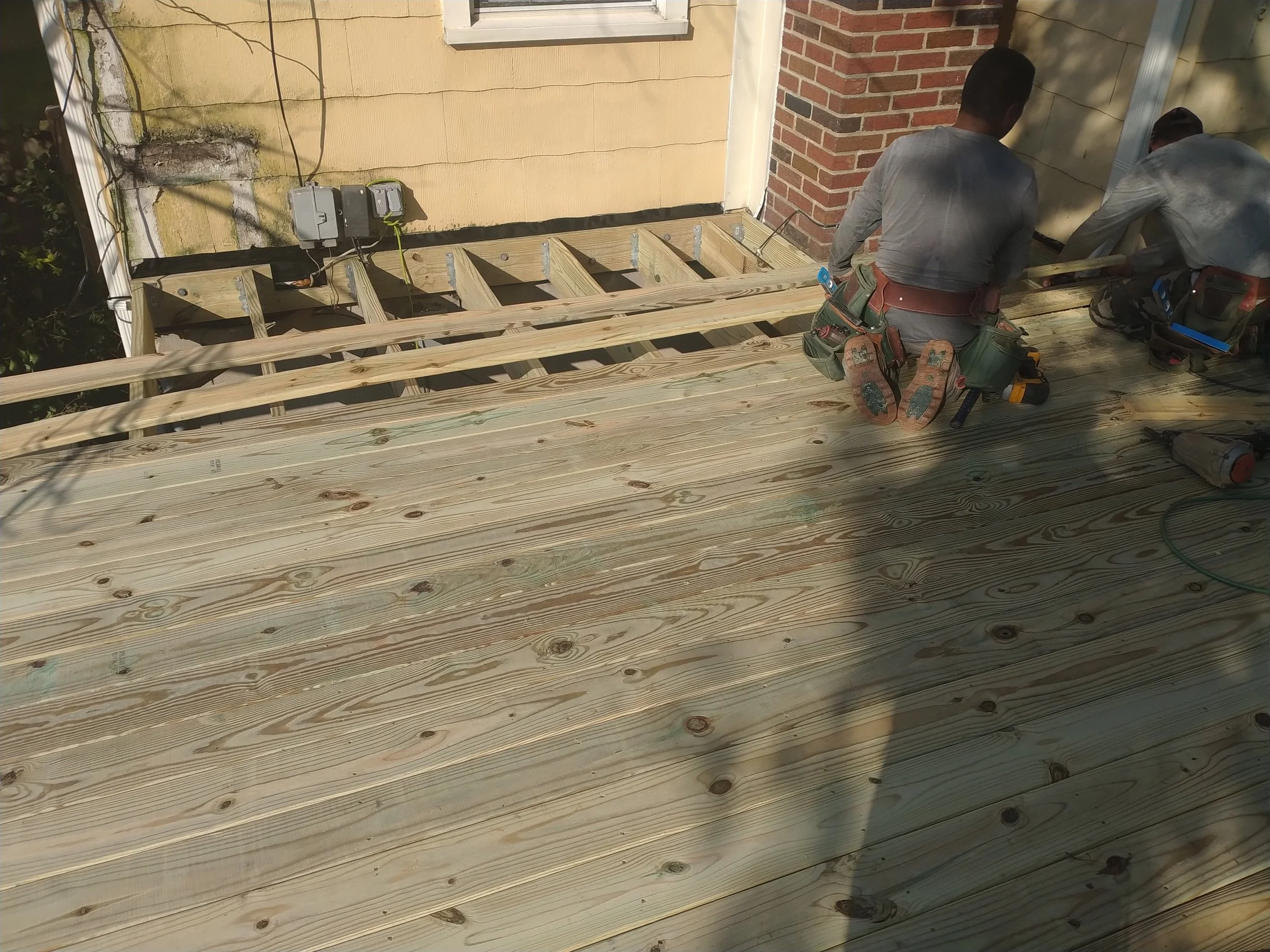 Structural elevated deck framing with pressure-treated lumber. Expert outdoor construction in Point Pleasant Beach, NJ. Custom wood deck construction project in Middletown. High-quality pressure-treated lumber and professional framing. Custom Deck, R