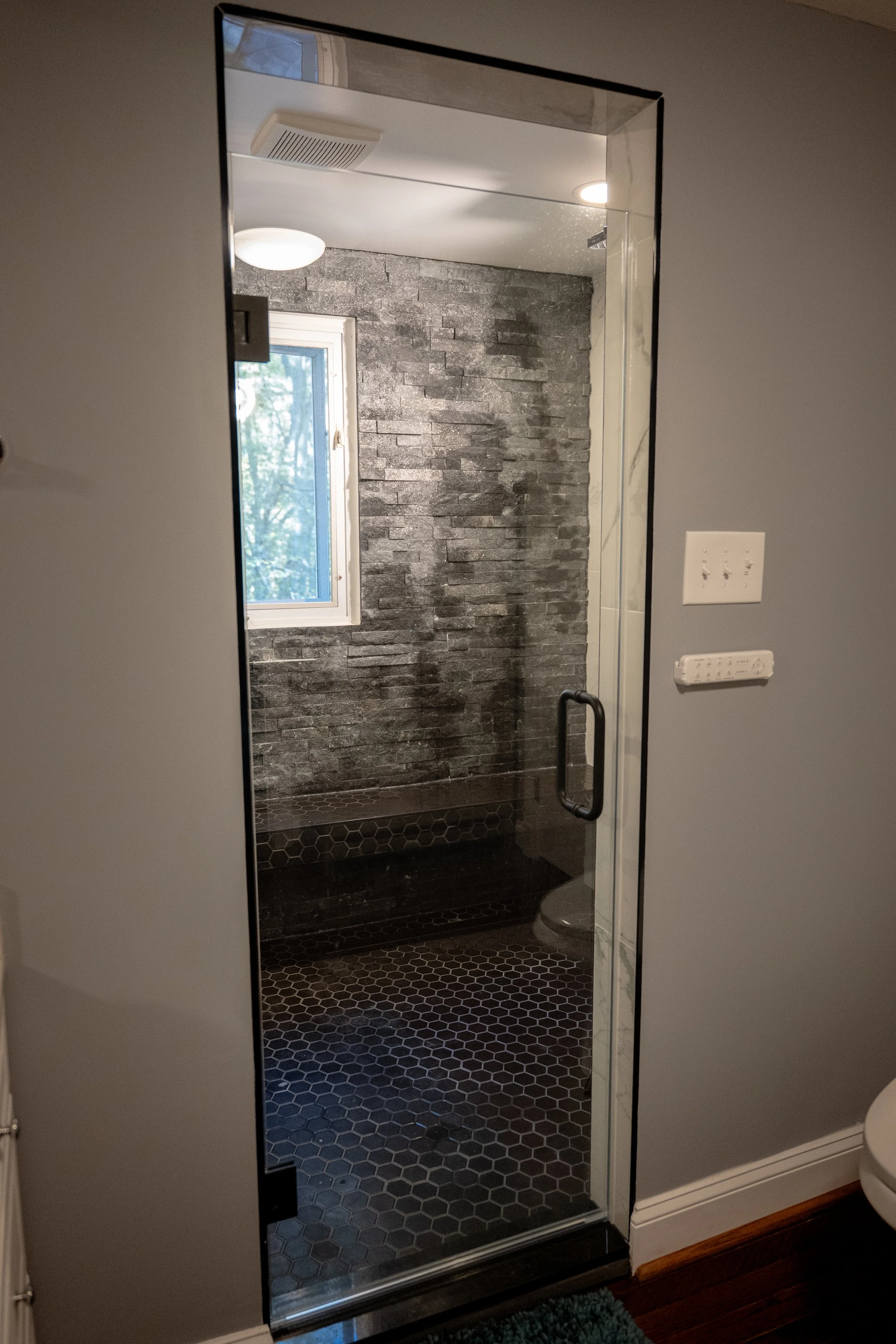 Precision hexagonal tile work and custom shower niche. Artistic bathroom tiling and functional design in Chevy Chase.