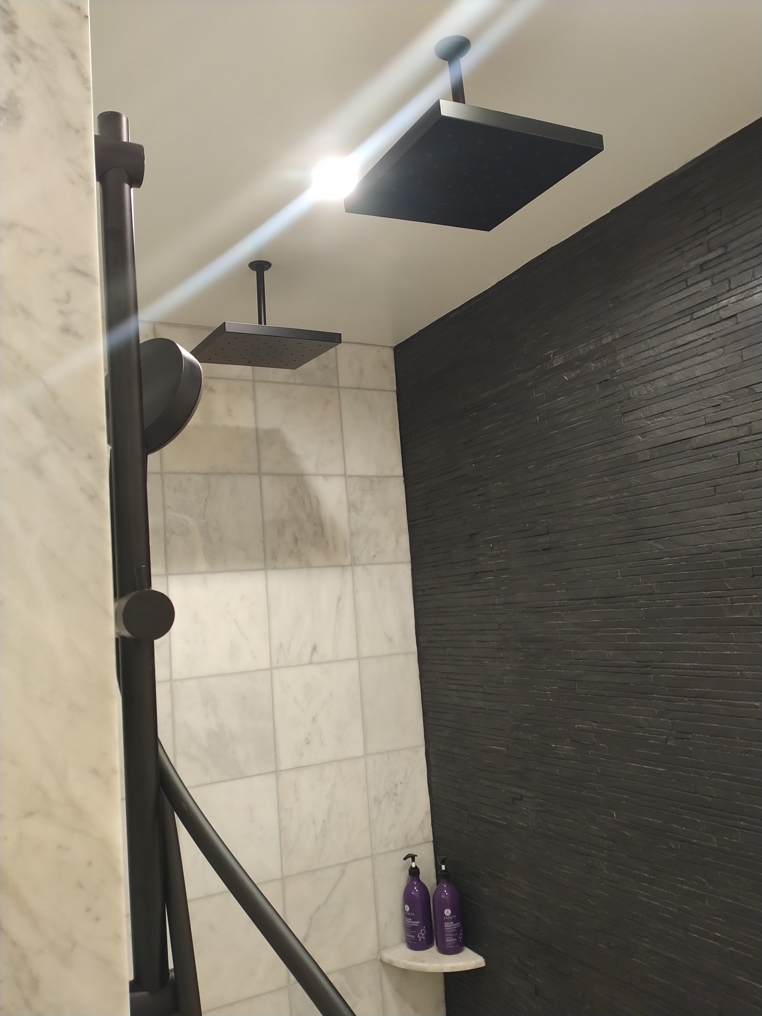 Luxury walk-in shower with seamless glass enclosure. Professional tiling and contemporary hardware installation in Columbia, MD.
