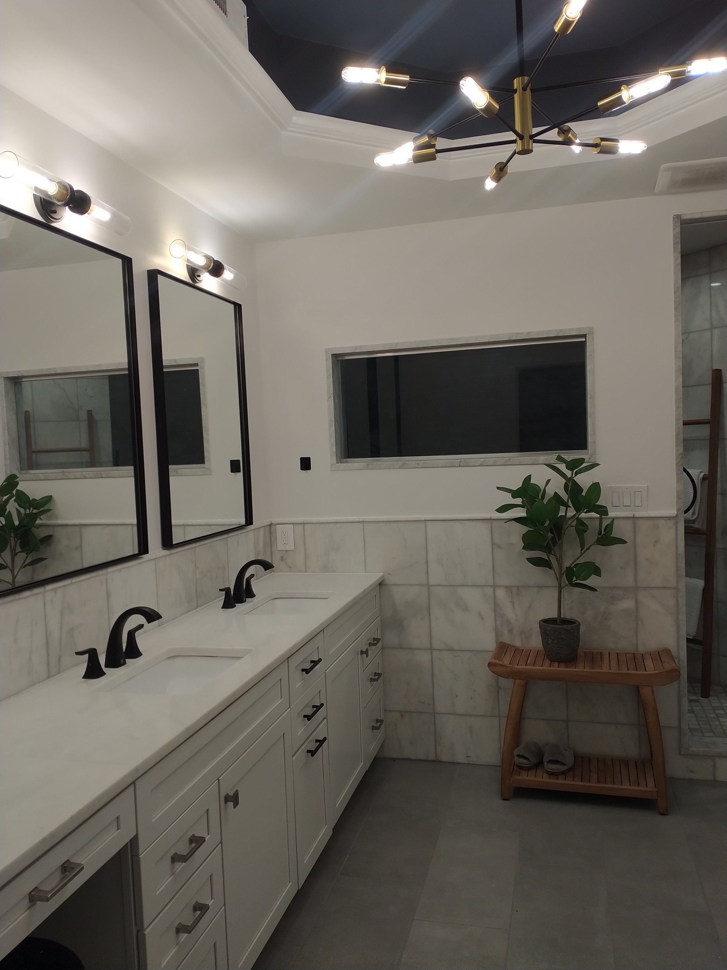 Luxury bathroom remodeling, marble tiles, luxury tiles, double vanity, metal framed mirror, chandelier, free standing shower