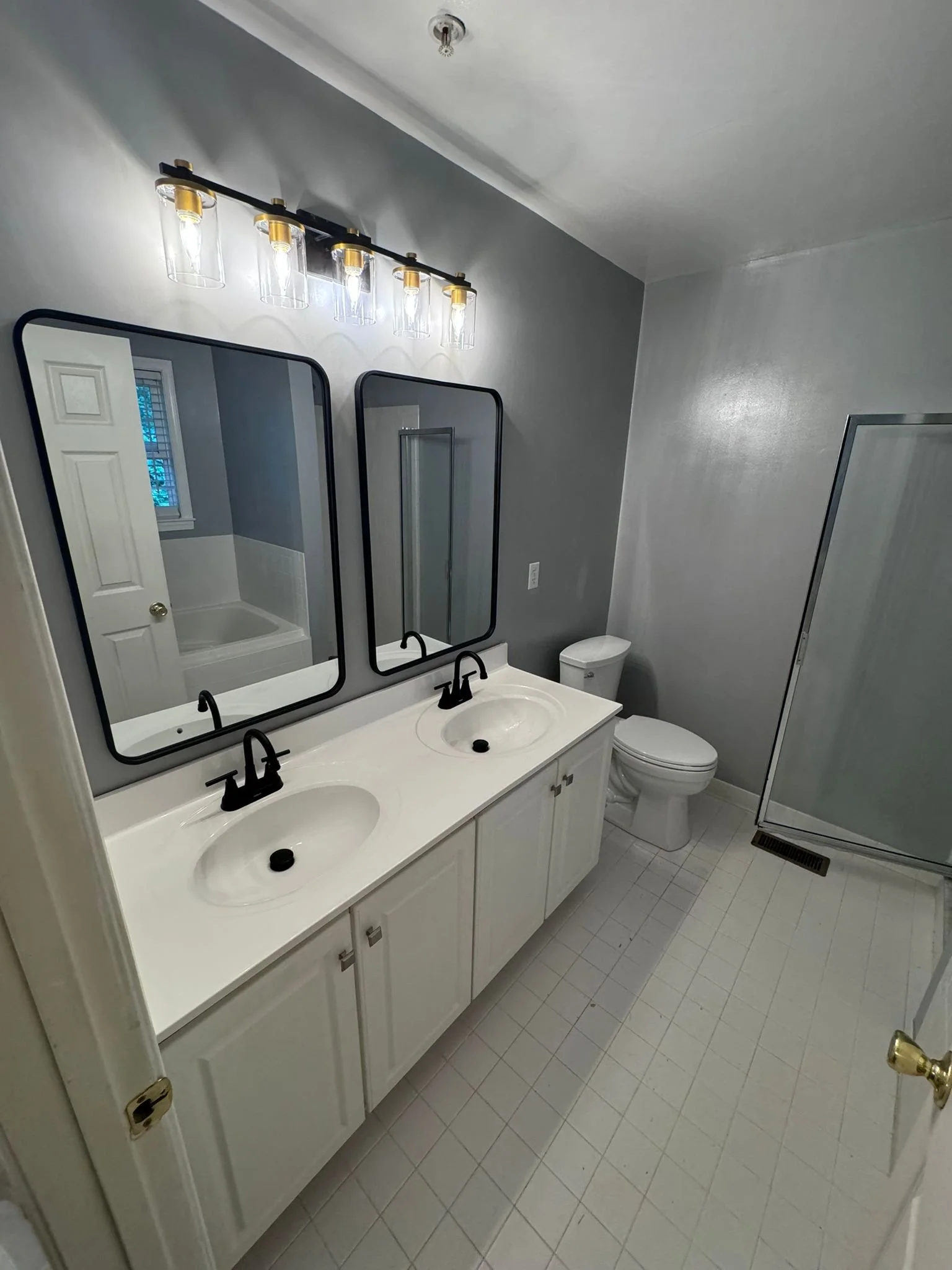 Custom bathroom vanity featuring dual circular mirrors and modern lighting. Premium cabinetry for luxury homes in Long Branch, NJ.