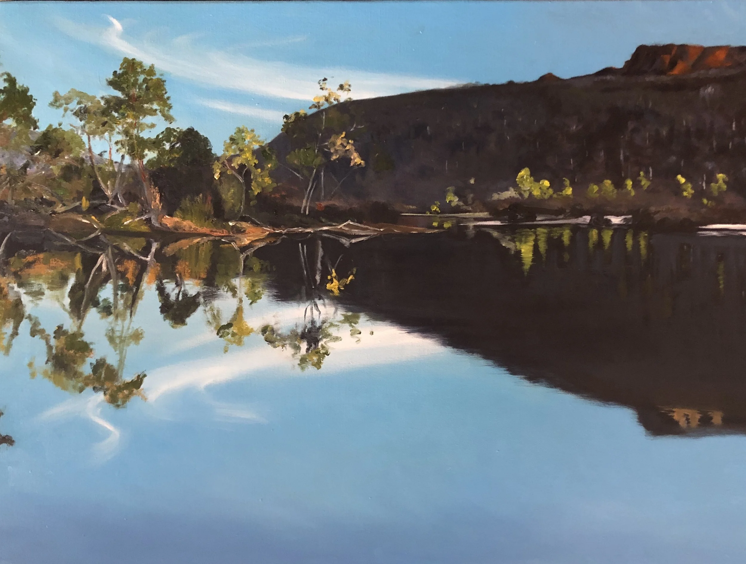 A landscape painting of a river reflecting trees, a hill, and a blue sky with wispy clouds.
