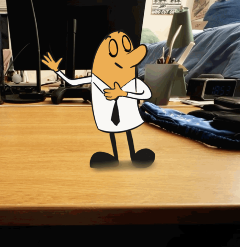 Animated cartoon character waving on a wooden desk with office supplies and a bed in the background.