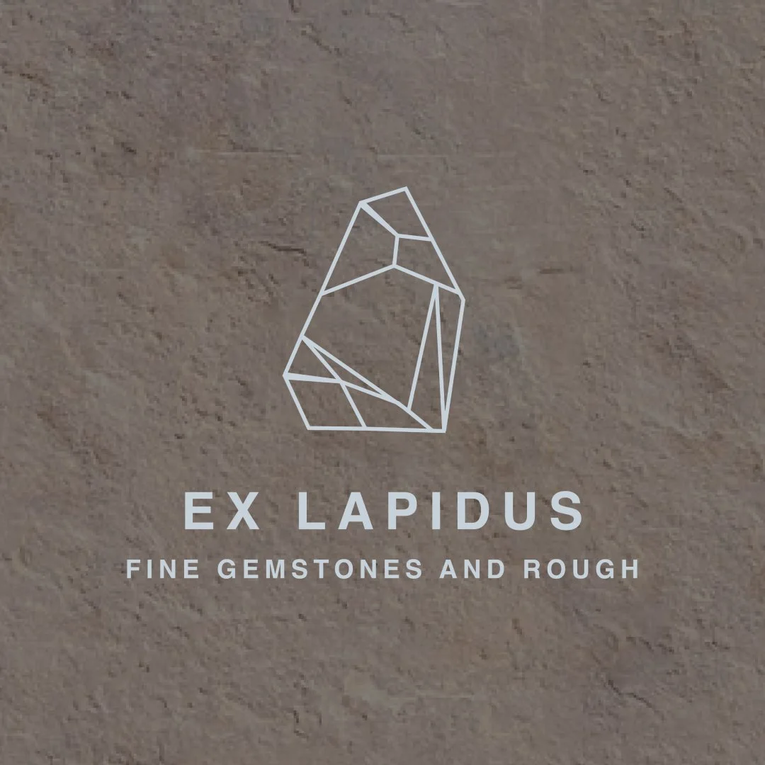 Log with geometric gem graphic and text reading "Ex Lapidus: Fine Gemstones and Rough" on a beige background.