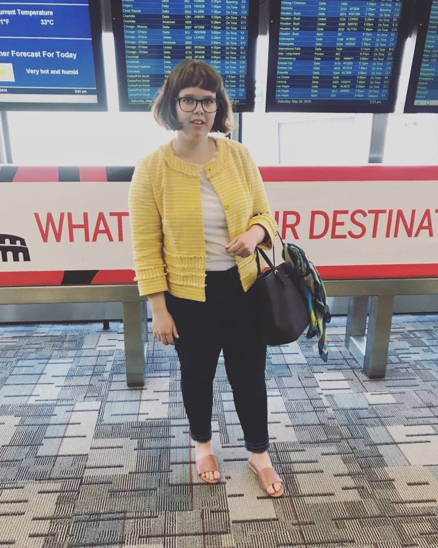 Photo of Marin at the airport in front of the departures board