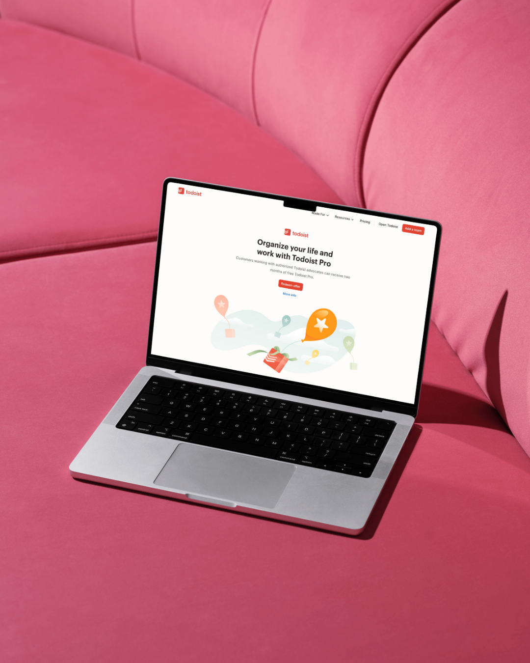 Photo of a laptop on a pink sofa with Todoist pulled up on the screen