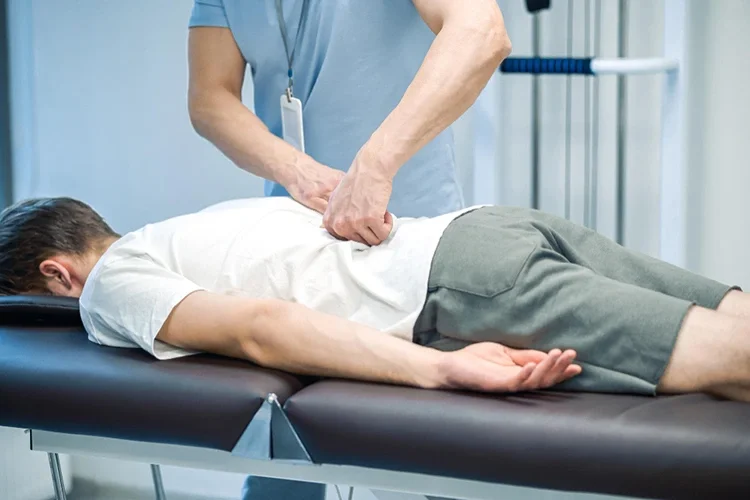A chiropractor performing a gentle lumbar adjustment on a patient to reduce disc pressure and improve spinal alignment.