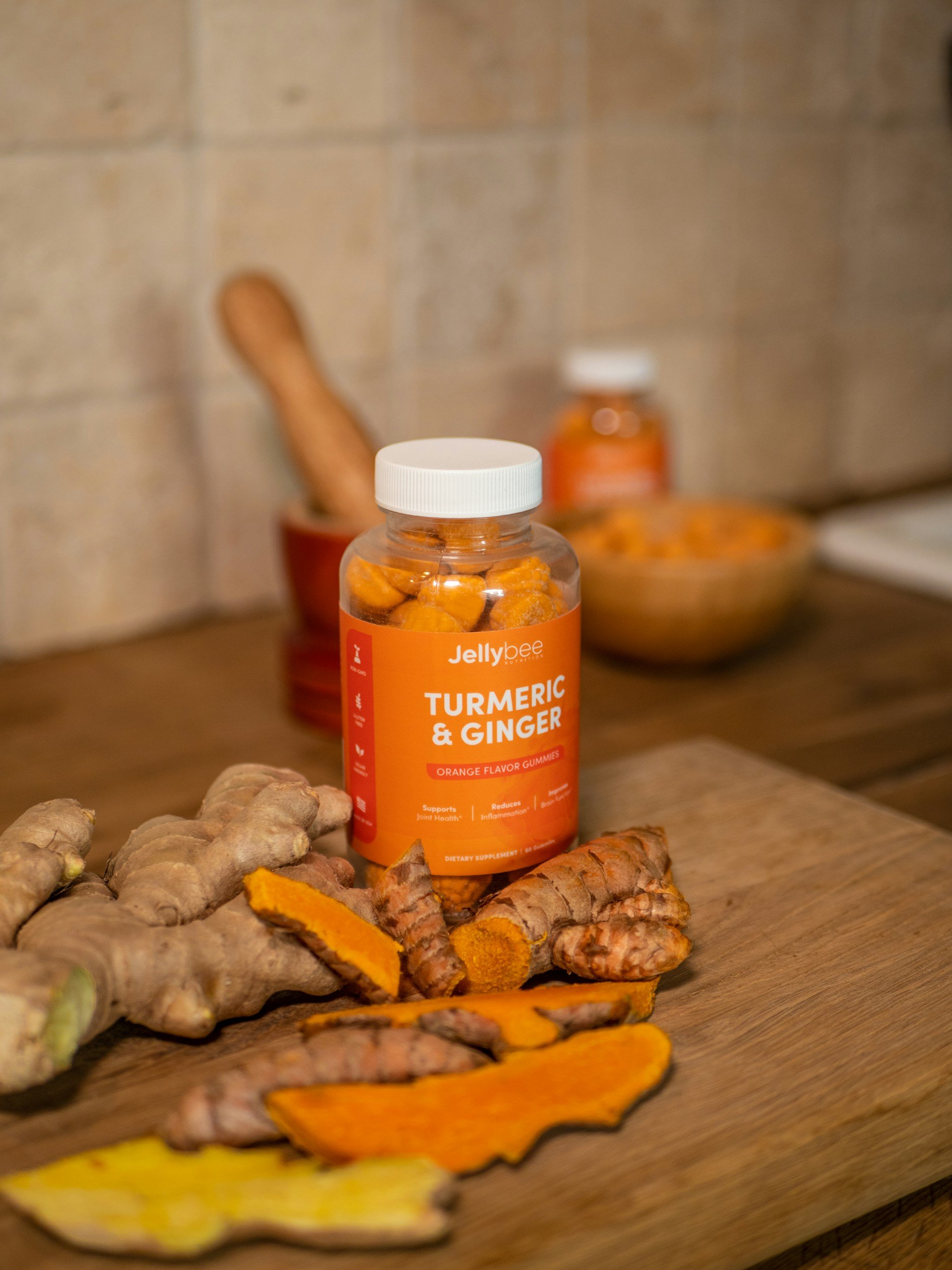 A photo of fresh turmeric, ginger, and organic supplement capsules.