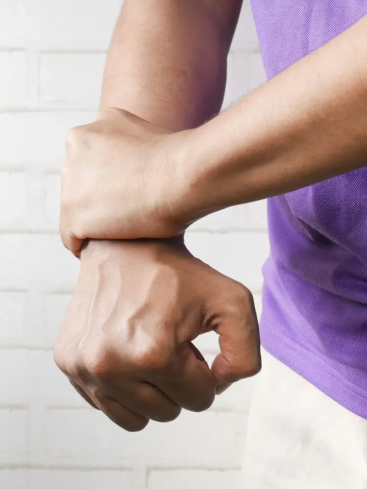 Close-up of a person holding their wrist in pain, illustrating joint pain and arthritis symptoms.
