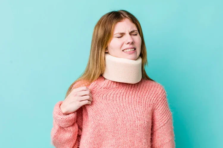 A photo of a woman wearing a neck brace due to a whiplash injury from a car accident, appearing stressed and anxious.