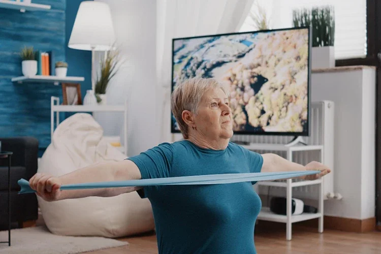 Patient performing rehab exercises with a resistance band to strengthen back muscles.