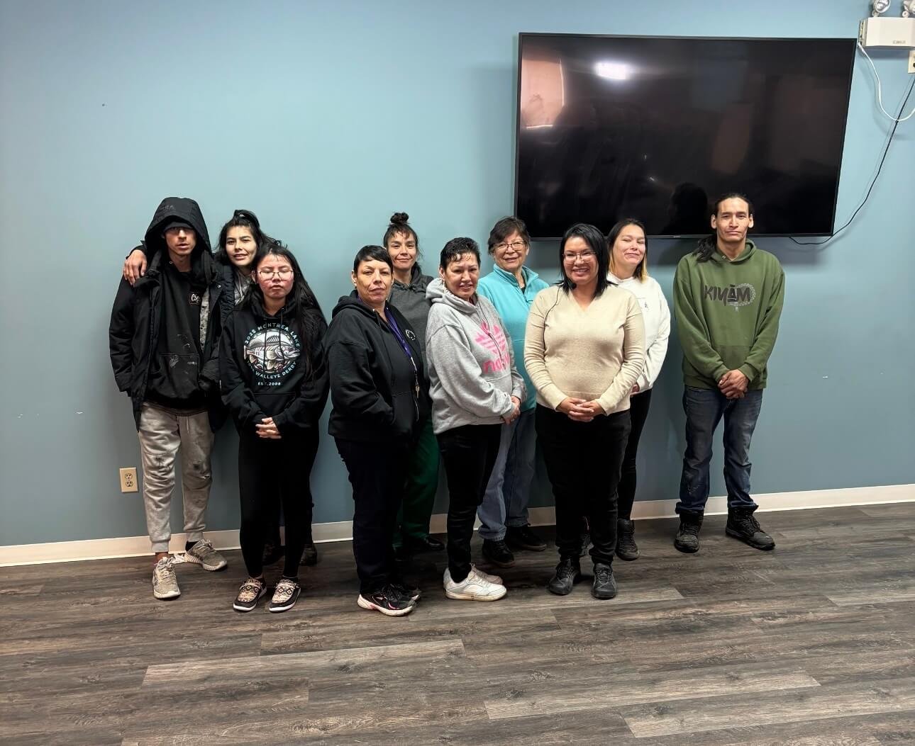 Group of nine diverse women and men standing together in a room after attending a financial literacy workshop with Brenda Dreaver.