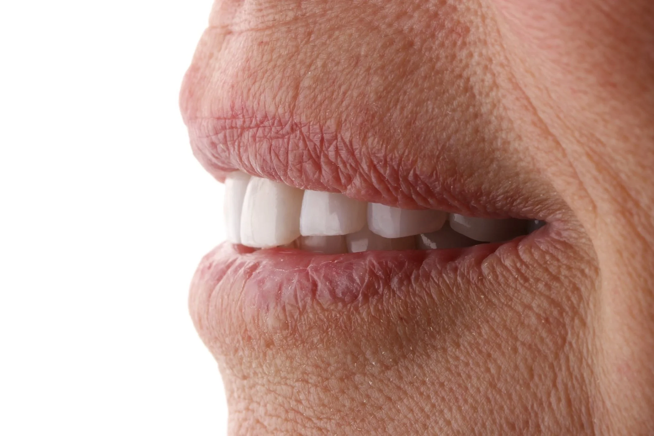 Close-up of a person's slightly parted lips revealing upper front teeth.