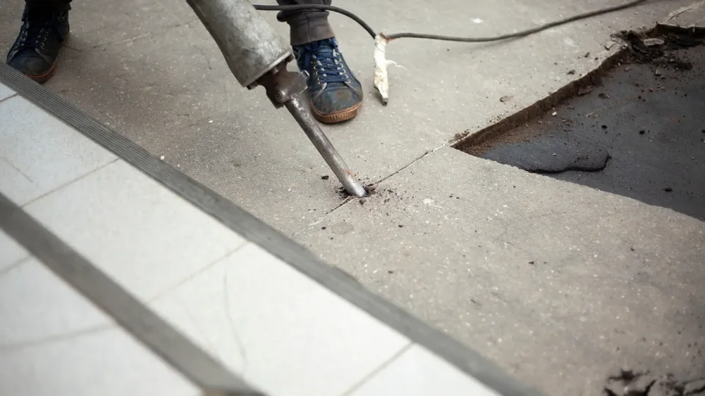 Jackhammer breaking a concrete slab during concrete removal in St. Catharines