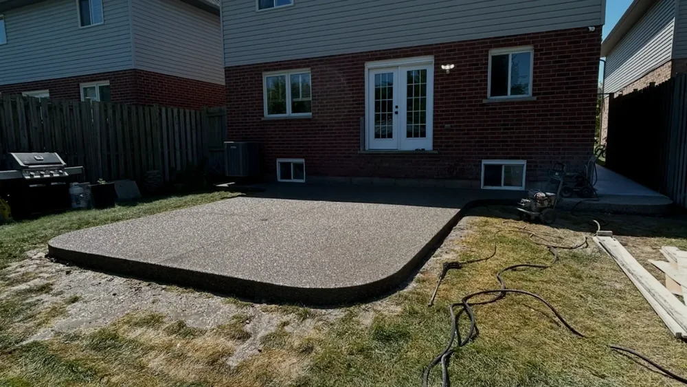 Exposed aggregate concrete patio with rounded corner in Grimsby