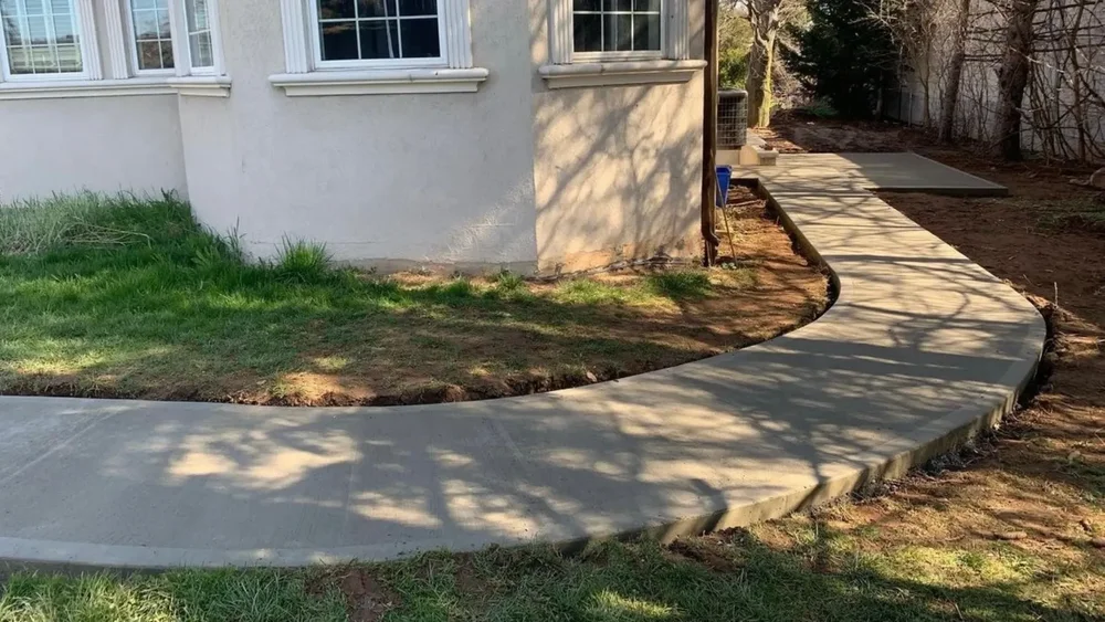 Curved concrete walkway and patio path along a Grimsby home