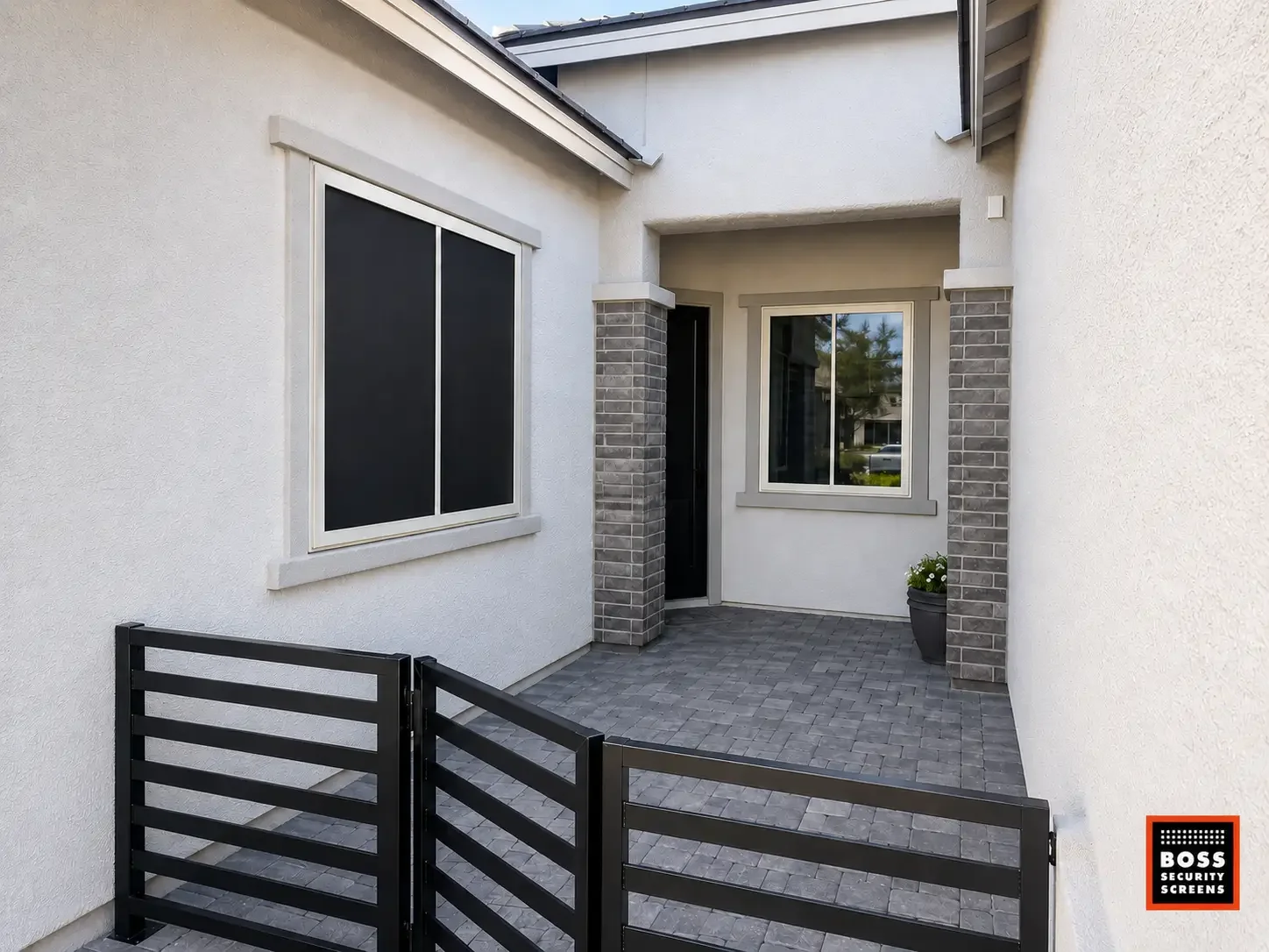 Calabasas courtyard with dark security screen panels on the window and entryway, preserving the home’s clean exterior while adding discreet protection.