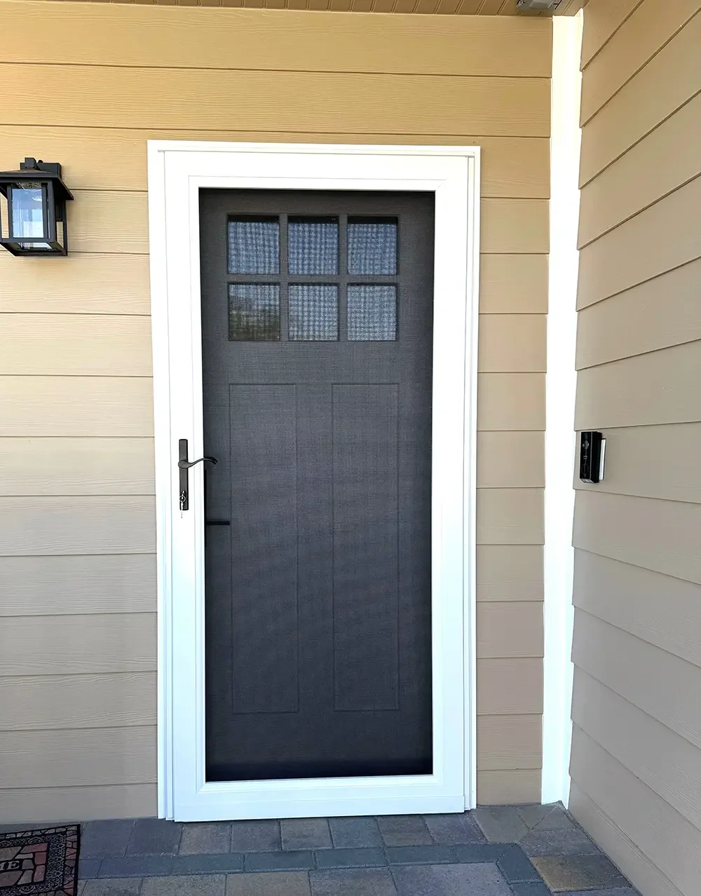 Front security screen door with stainless steel mesh installed on a residential entry door