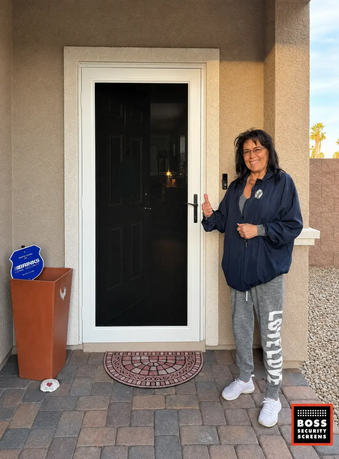 smiling-homeowner-thumbs-up-white-security-screen-door-covered-stucco-entryway.webp