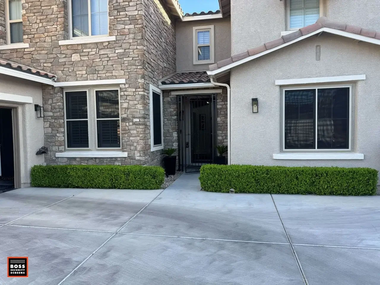 Encino home exterior with dark security screen panels on windows and entryway, creating a physical barrier while keeping the façade clean and residential.
