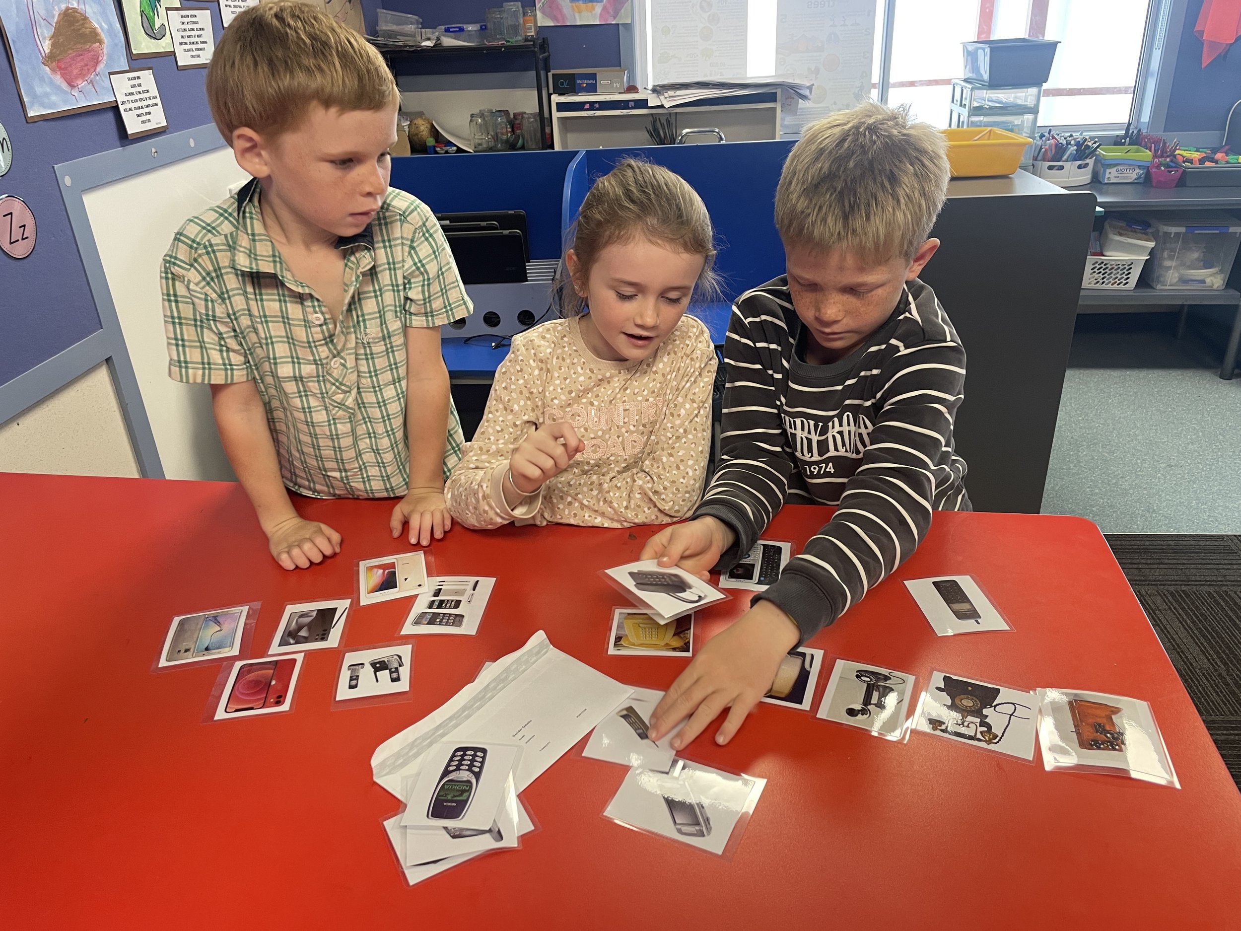 Children working together with picture cards of different electronic devices