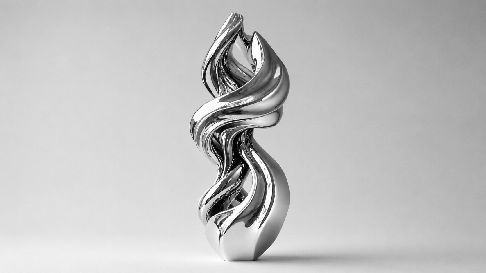 A shiny, abstract silver sculpture with swirling, flowing shapes against a plain gray background.