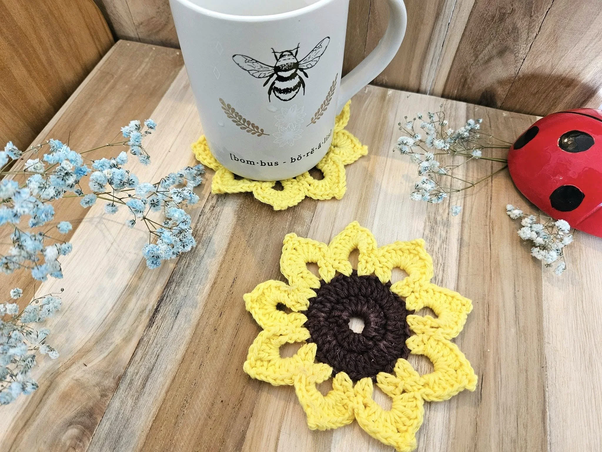 Sous verre tournesol fait main au crochet sur fond en bois avec une tasse