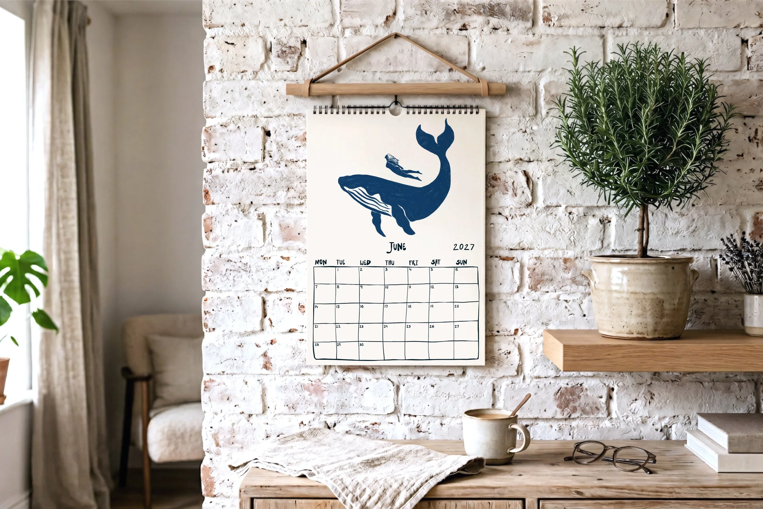 June calendar page illustrated with a humpback whale and a freediver swimming together in the ocean