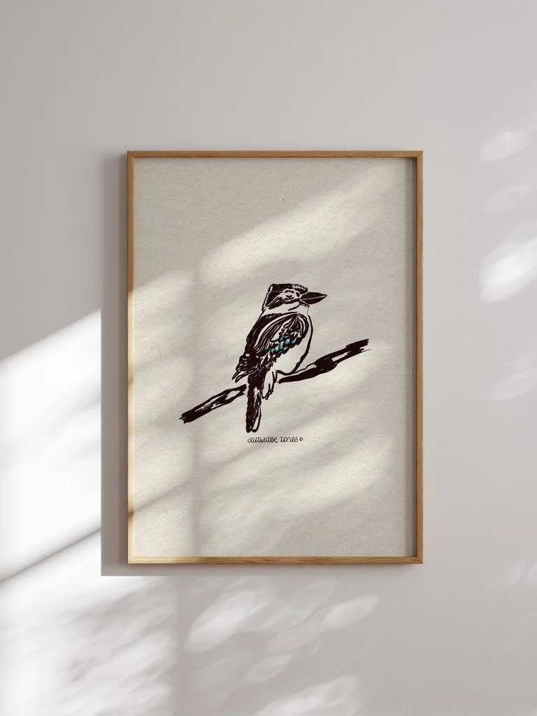 Hand-drawn ink illustration of an Australian kookaburra perched on a branch with a flash of blue wing feathers by saltwater tones