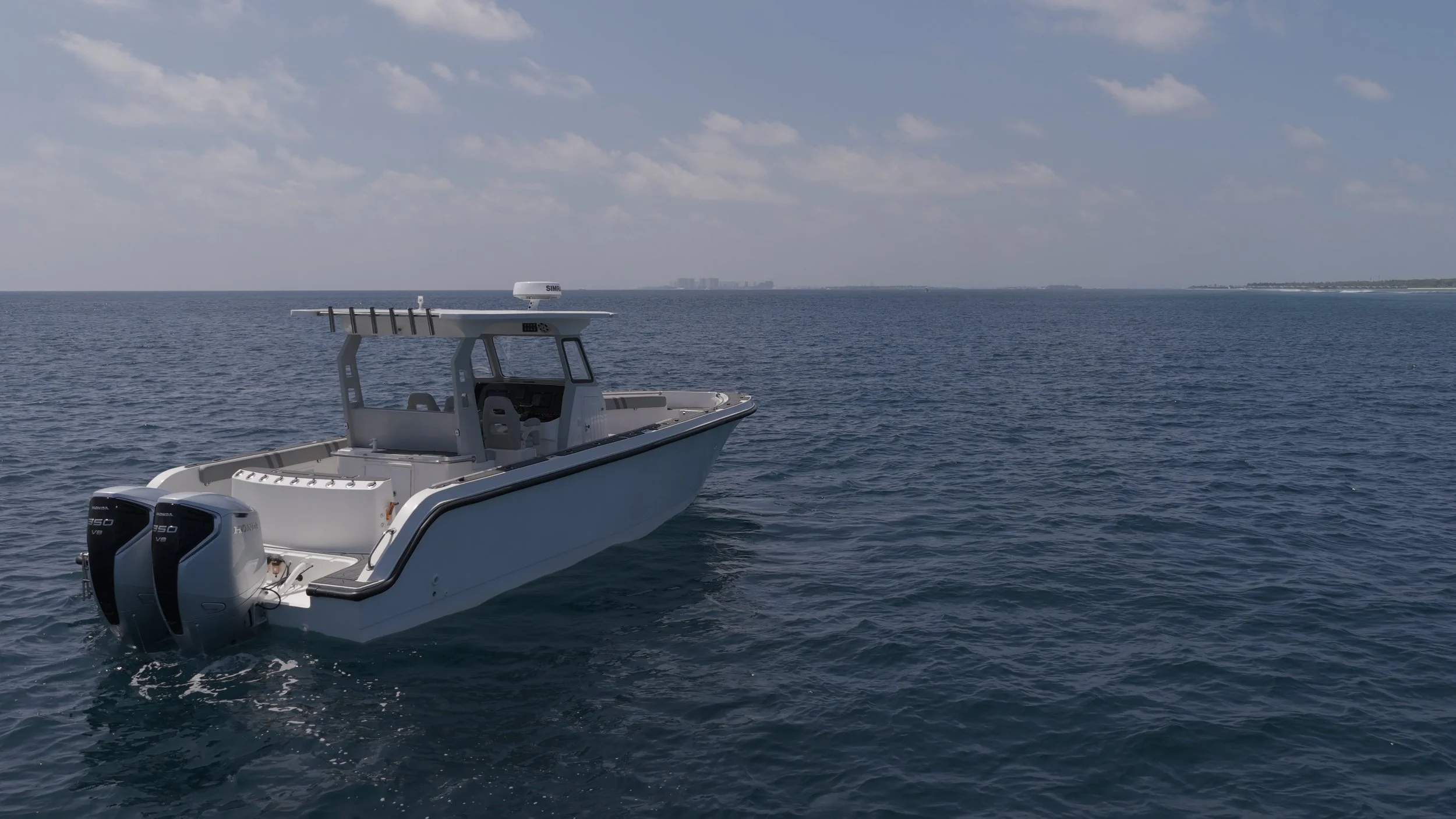 A white motorboat with twin outboard engines sailing on calm blue ocean water under a partly cloudy sky.