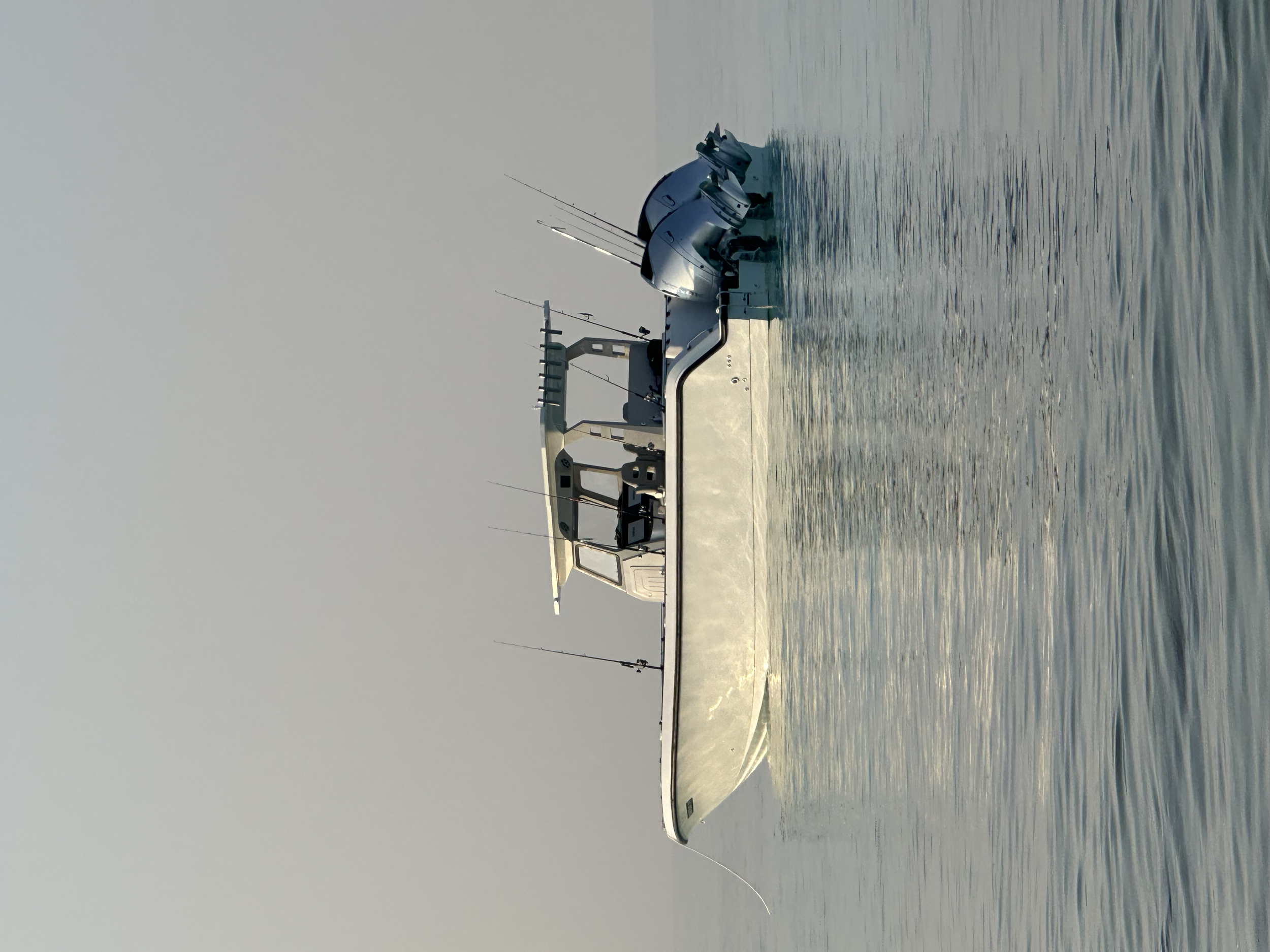A boat floating on calm water with a clear sky in the background.