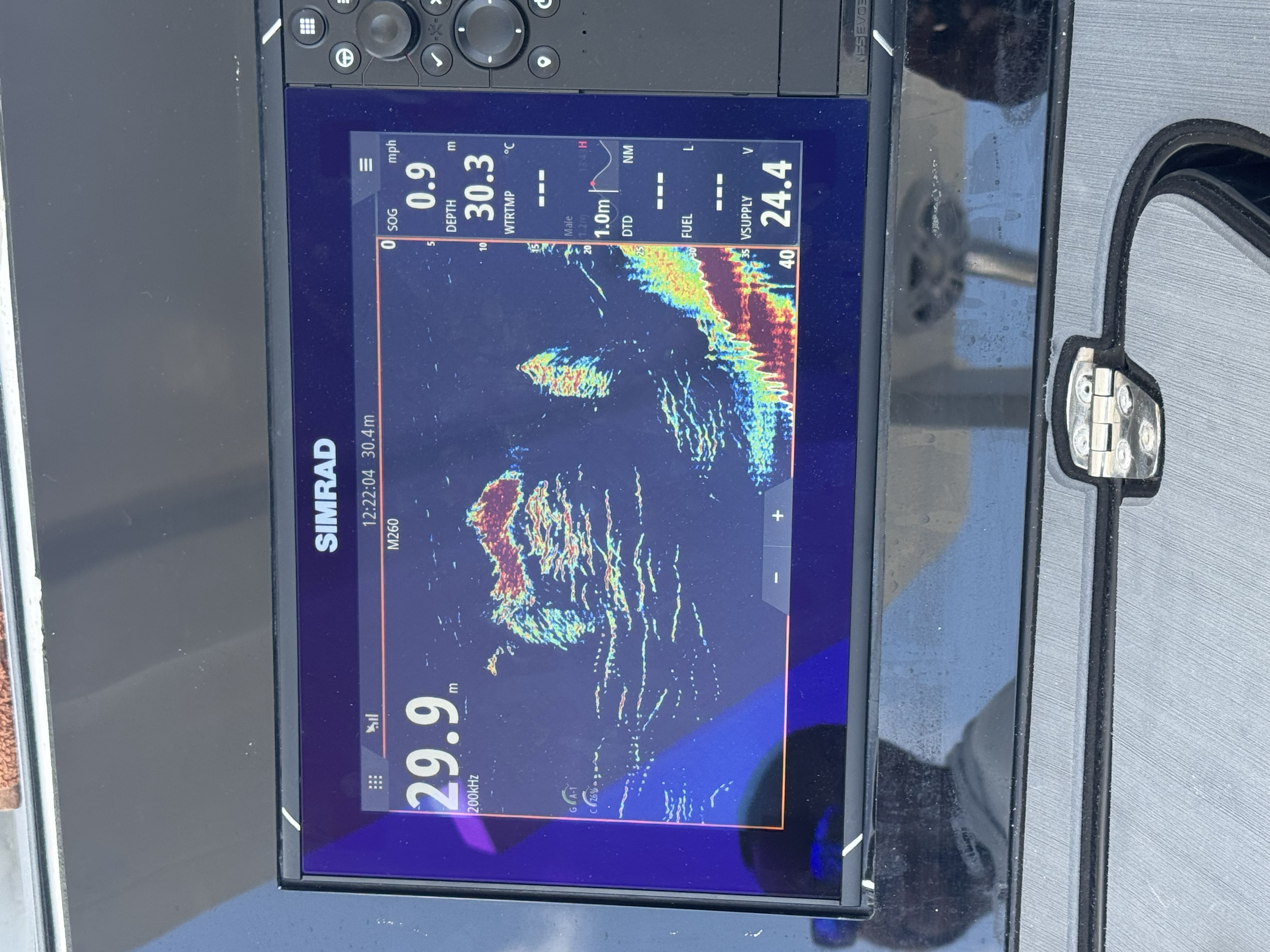 A fishfinder display showing underwater sonar readings with depth, temperature, and fish arches at approximately 29.9 feet.
