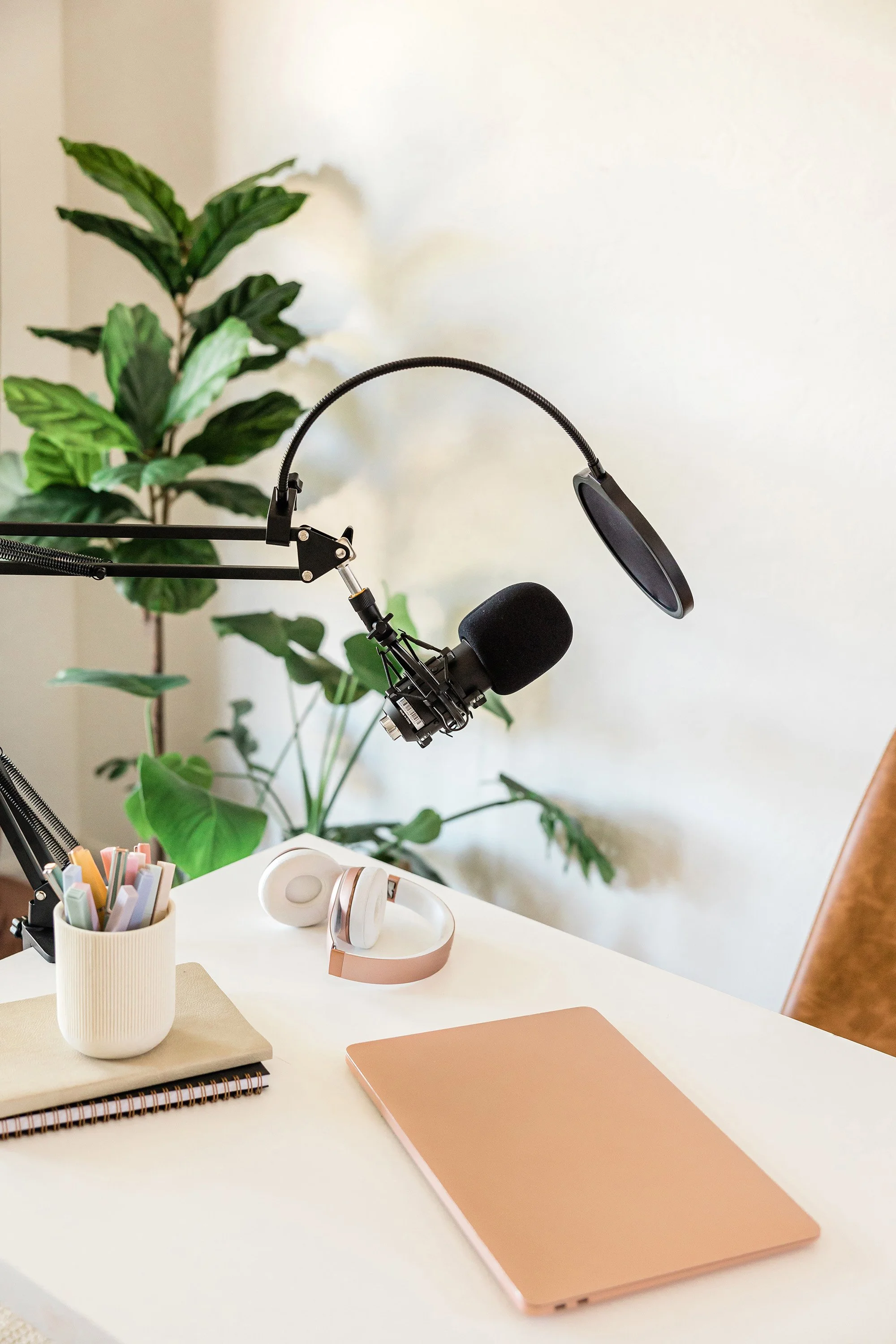 podcast office setup with microphone, headphones and a laptop