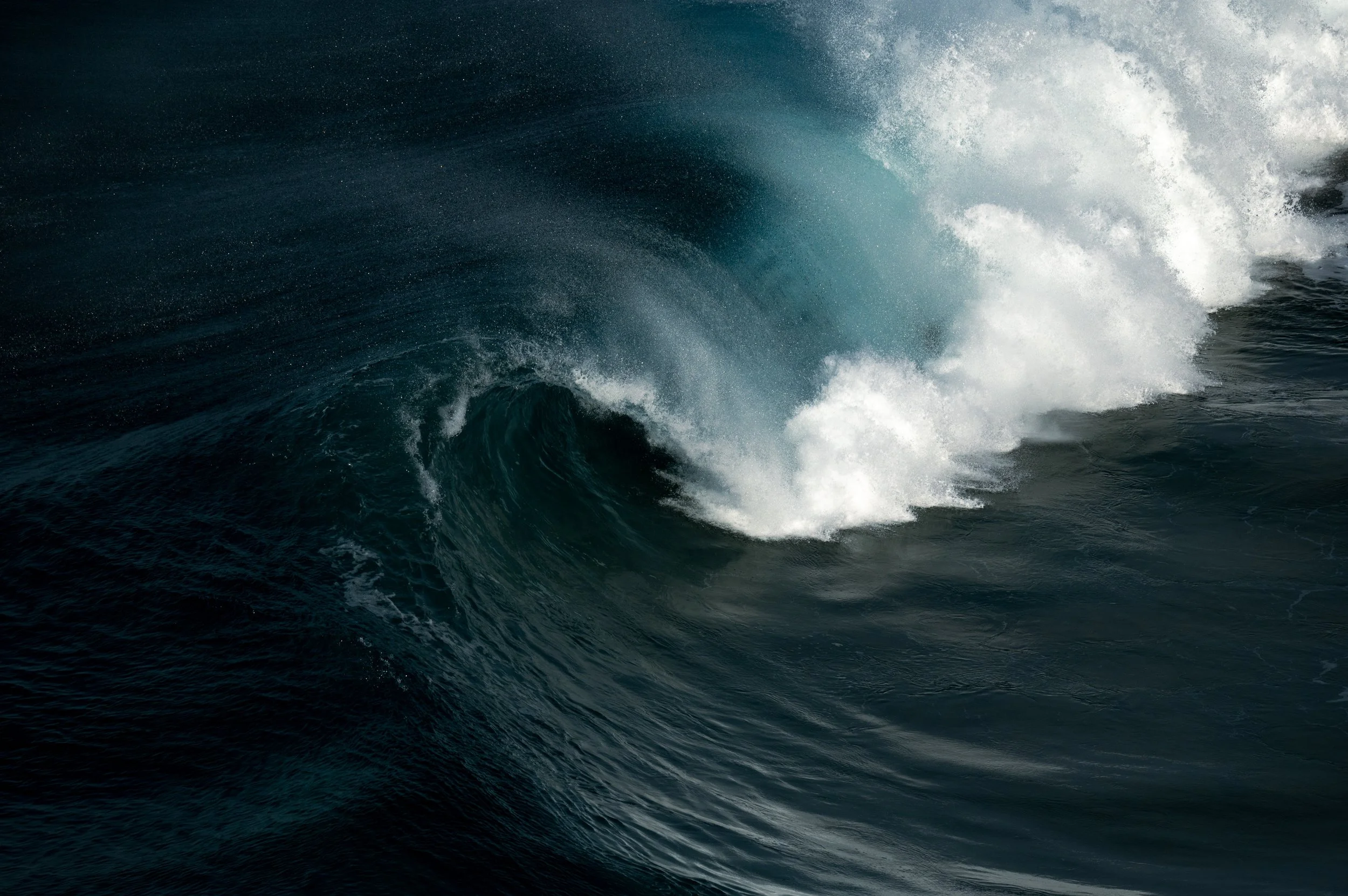 Vague de mer dans l'océan avec de l'écume blanche et des eaux bleues profondes.